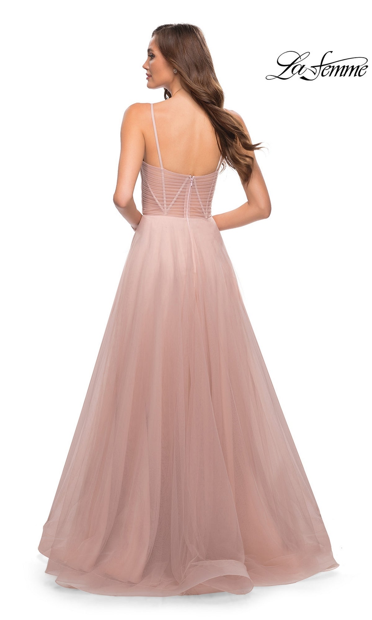 Woman faces away in a light pink La Femme Sheer-Waist Long A-Line Prom Dress 29076, featuring a fitted bodice with sheer stripes and spaghetti straps.